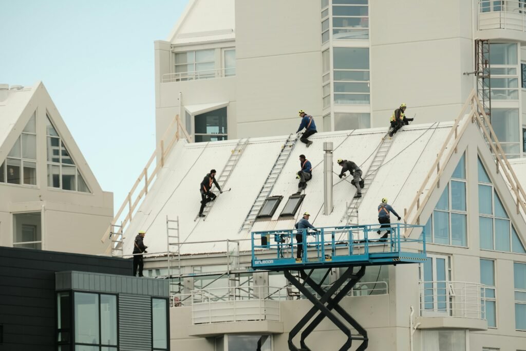pexels photo 32608171 32608171 Construction workers repairing a modern roof in Reykjavík, highlighting teamwork and safety.