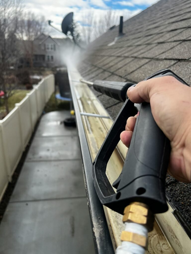 pexels photo 35153375 35153375 Close-up of gutter cleaning with pressure washer, outdoors, during the day.